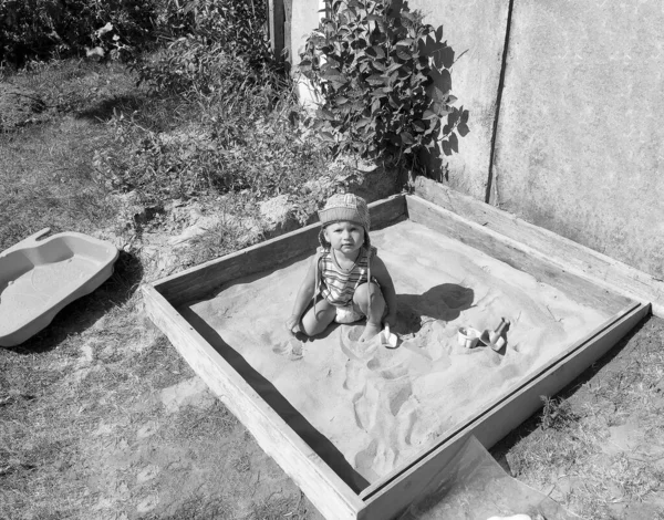 어린이 구덩이에서 포즈를 취하는 사진사의 아름다운 샌들에 모래로 캐리어 아이를 — 스톡 사진
