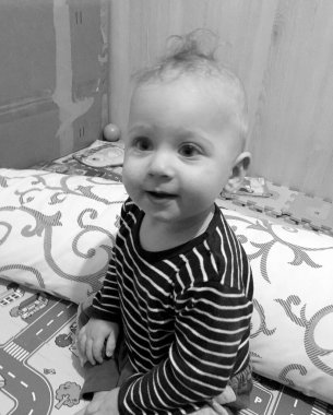 Renkli fotoğraf için poz veren çocuk yüzlü güzel erkek bebek, çocuk imajı olan erkek bebek kadrosu, beyaz yüz ifadesi, çocuk suratlı sağlıklı bir erkek çocuğu, iyi bir çekim için dinleniyor.