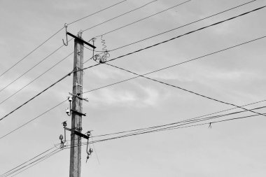 Renkli arka planda kablo olan elektrik direği yakın planda, elektrik direği ile gökyüzünün altında halat kablosu, konut binaları için elektrik direği hattı kablosu.