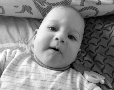 Renkli fotoğraf için poz veren çocuk yüzlü güzel erkek bebek, çocuk imajı olan erkek bebek kadrosu, beyaz yüz ifadesi, çocuk suratlı sağlıklı bir erkek çocuğu, iyi bir çekim için dinleniyor.