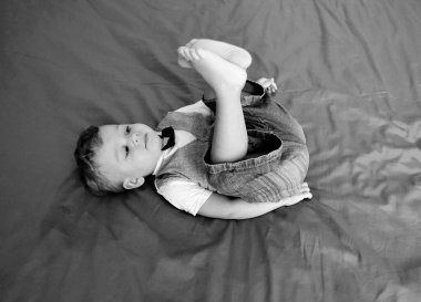 Renkli fotoğraf için poz veren çocuk yüzlü güzel erkek bebek, çocuk imajı olan erkek bebek kadrosu, beyaz yüz ifadesi, çocuk suratlı sağlıklı bir erkek çocuğu, iyi bir çekim için dinleniyor.