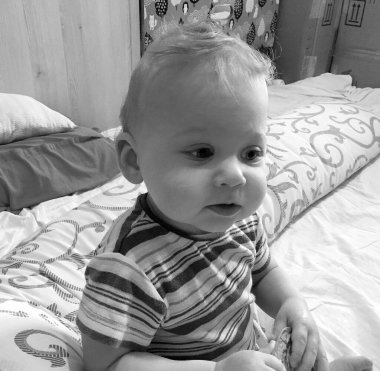 Renkli fotoğraf için poz veren çocuk yüzlü güzel erkek bebek, çocuk imajı olan erkek bebek kadrosu, beyaz yüz ifadesi, çocuk suratlı sağlıklı bir erkek çocuğu, iyi bir çekim için dinleniyor.