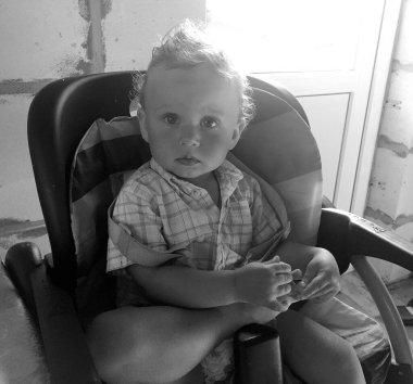 Renkli fotoğraf için poz veren çocuk yüzlü güzel erkek bebek, çocuk imajı olan erkek bebek kadrosu, beyaz yüz ifadesi, çocuk suratlı sağlıklı bir erkek çocuğu, iyi bir çekim için dinleniyor.