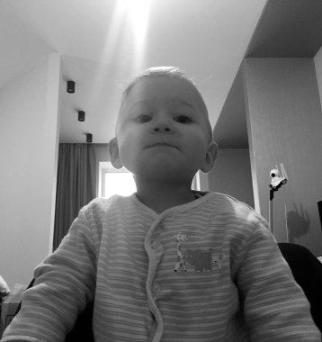 Renkli fotoğraf için poz veren çocuk yüzlü güzel erkek bebek, çocuk imajı olan erkek bebek kadrosu, beyaz yüz ifadesi, çocuk suratlı sağlıklı bir erkek çocuğu, iyi bir çekim için dinleniyor.