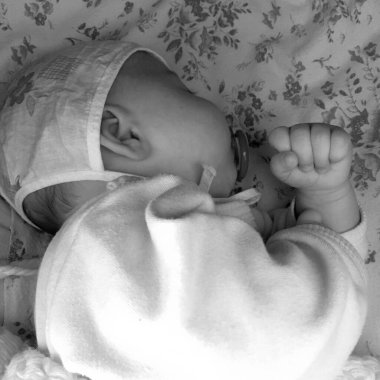 Renkli fotoğraf için fotoğrafçı pozu veren uyuyan erkek bebek, uyuyan bebek emziği, gülümseyen yüz, çocuk emziğindeki sağlıklı uyuyan erkek çocuğu.