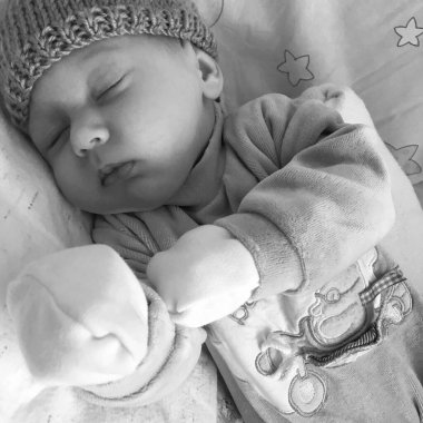 Çocuk şapkalı, çocuk şapkalı güzel bir çocuk. Renkli fotoğraf için poz veriyor. Kadro, çocuk şapkasından uyuyan bir çocuktan oluşuyor.