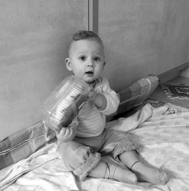 Renkli fotoğraf için poz veren çocuk yüzlü güzel erkek bebek, çocuk imajı olan erkek bebek kadrosu, beyaz yüz ifadesi, çocuk suratlı sağlıklı bir erkek çocuğu, iyi bir çekim için dinleniyor.