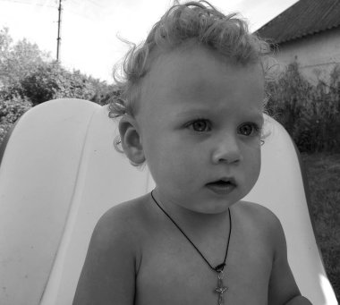 Renkli fotoğraf için poz veren çocuk yüzlü güzel erkek bebek, çocuk imajı olan erkek bebek kadrosu, beyaz yüz ifadesi, çocuk suratlı sağlıklı bir erkek çocuğu, iyi bir çekim için dinleniyor.