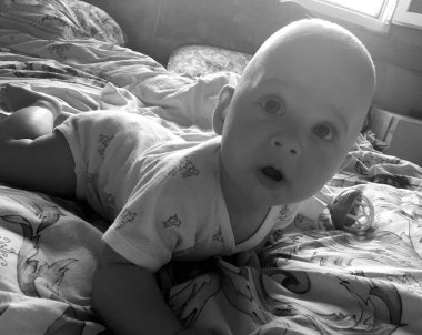 Renkli fotoğraf için poz veren çocuk yüzlü güzel erkek bebek, çocuk imajı olan erkek bebek kadrosu, beyaz yüz ifadesi, çocuk suratlı sağlıklı bir erkek çocuğu, iyi bir çekim için dinleniyor.