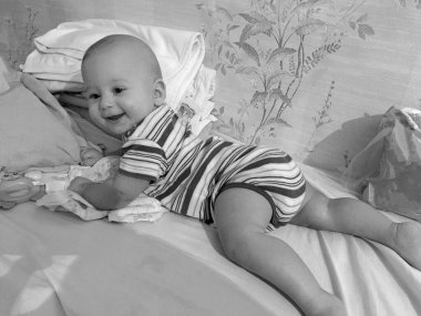 Renkli fotoğraf için poz veren çocuk yüzlü güzel erkek bebek, çocuk imajı olan erkek bebek kadrosu, beyaz yüz ifadesi, çocuk suratlı sağlıklı bir erkek çocuğu, iyi bir çekim için dinleniyor.