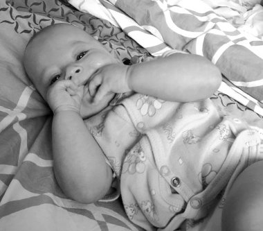 Renkli fotoğraf için poz veren çocuk yüzlü güzel erkek bebek, çocuk imajı olan erkek bebek kadrosu, beyaz yüz ifadesi, çocuk suratlı sağlıklı bir erkek çocuğu, iyi bir çekim için dinleniyor.