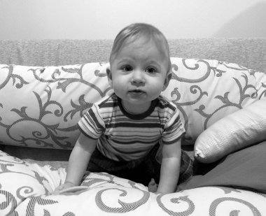 Renkli fotoğraf için poz veren çocuk yüzlü güzel erkek bebek, çocuk imajı olan erkek bebek kadrosu, beyaz yüz ifadesi, çocuk suratlı sağlıklı bir erkek çocuğu, iyi bir çekim için dinleniyor.