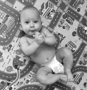 Renkli fotoğraf için poz veren çocuk yüzlü güzel erkek bebek, çocuk imajı olan erkek bebek kadrosu, beyaz yüz ifadesi, çocuk suratlı sağlıklı bir erkek çocuğu, iyi bir çekim için dinleniyor.