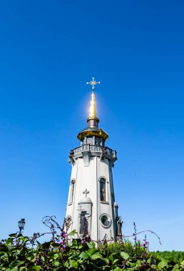 Hristiyan kilisesi, yüksek çan kulesinde ibadet için kesişiyor. Çan kulesinde haçı olan güzel bir kiliseden samimi bir duaya kadar fotoğraf çekiliyor. Çan kulesi üzerinde kilise duası açık gökyüzü üzerinde.
