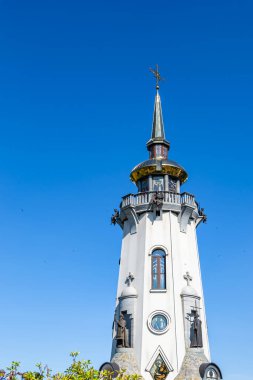 Hristiyan kilisesi, yüksek çan kulesinde ibadet için kesişiyor. Çan kulesinde haçı olan güzel bir kiliseden samimi bir duaya kadar fotoğraf çekiliyor. Çan kulesi üzerinde kilise duası açık gökyüzü üzerinde.