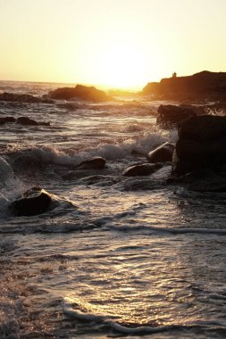 ocean waves and sunset, rocky cliff beach 
