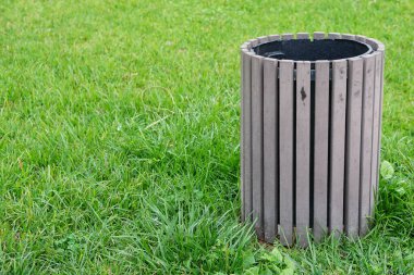 Yeşil çayır üzerindeki çöp tenekesi 