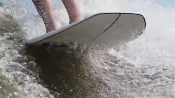 Surfista saltando a velocidad en olas usando wakeboard salpicando gotas de agua a la cámara — Vídeo de stock