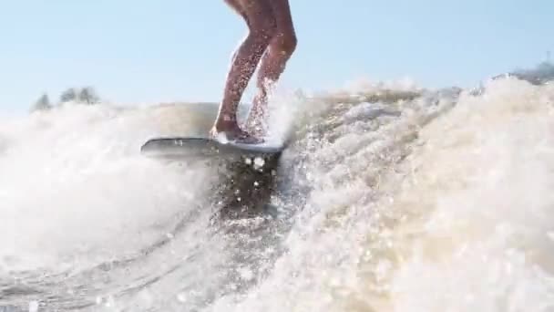 Surfer springen op snelheid in golven met behulp van wakeboard spatten water druppels naar de camera — Stockvideo