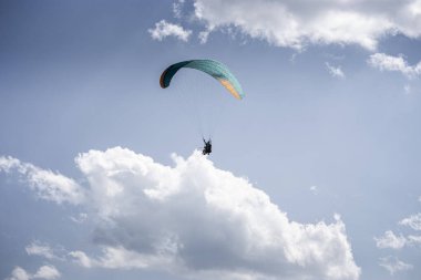 Bir çift eğitmenle paraşütle atlamak. Güzel beyaz kabarık bulutları olan parlak mavi bir gökyüzü. Aktif maceralarla vakit geçirmek. Gürcistan 'da turizm
