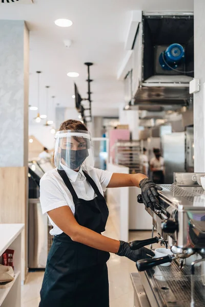 가리개를 착용하고 빵집이나 식당에서 일하며 머신을 사용하는 아름다운 노동자 코로나 — 스톡 사진