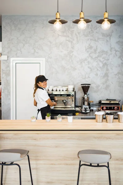 Fırında ya da fast food restoranında çalışan ve kahve makinesi kullanan güzel ve mutlu genç bir bayan işçi. Küçük işletme konseptinde pozitif insanlar.