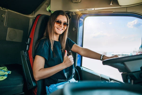 美しい若い女性のプロのトラック運転手座って大きなトラックを運転の肖像画 車の中だ 人と交通の概念 — ストック写真