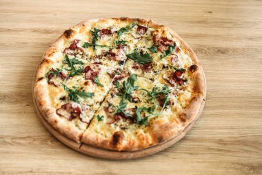 Ahşap masada taze pişmiş lezzetli pizza. Orijinal İtalyan yemek geçmişi. Pizza konsepti.