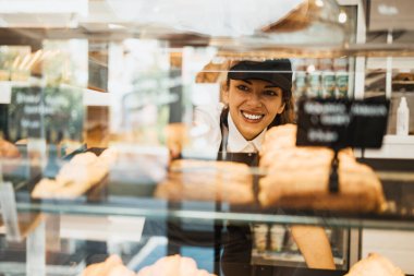 Modern bir fırında çalışan genç ve güzel bir bayan işçi..