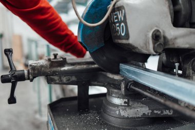 Alüminyum ve PVC profilleri kesen el işi işçisi. İmalat işleri. Seçici odaklanma. Alüminyum ve PVC pencere ve kapı üretim fabrikası.