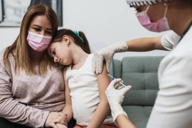 Ev ziyareti sırasında çocuk hastasına aşı yapan kadın doktor. Coronavirus veya Covid-19 salgını önleme ve koruma kavramı.