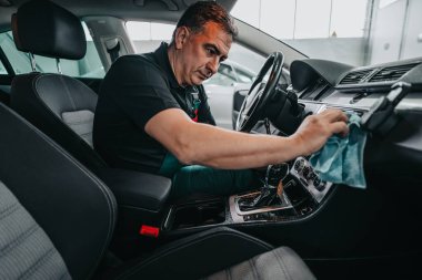 Profesyonel işçi temizleme iç ve ön panel, araba temizleme (veya valelik) konsepti. Seçici odaklanma. Ultra geniş açı..