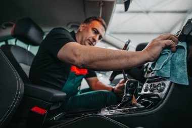 Profesyonel işçi temizleme iç ve ön panel, araba temizleme (veya valelik) konsepti. Seçici odaklanma. Ultra geniş açı..