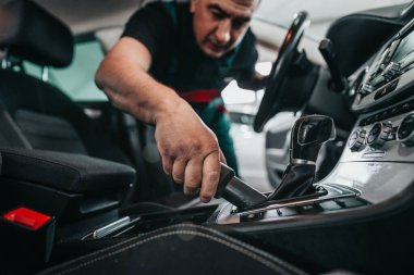 Profesyonel işçi temizleme iç ve ön panel, araba temizleme (veya valelik) konsepti. Seçici odaklanma. Ultra geniş açı..