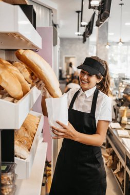 Modern bir fırında ya da fast food restoranında çalışan genç ve güzel bir bayan işçi..