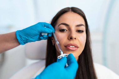 Güzel esmer kadın hasta botulinyum toksin iğneleri ya da hyaluronik asit doldurucu ile tıbbi ve güzellik tedavisine hazırlanıyor..