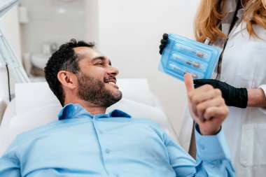 Yakışıklı orta yaşlı sakallı hasta botulinyum toksin iğneleri ya da hyaluronik asit doldurucu ile tıbbi ve güzellik tedavisine hazırlanıyor. Uzman danışma ve ürün sunumu.