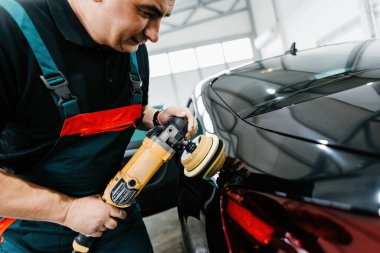 Araba bakım ve vale dükkanında lüks araba cilalayan profesyonel bir araba tamircisi. Ultra geniş açı..