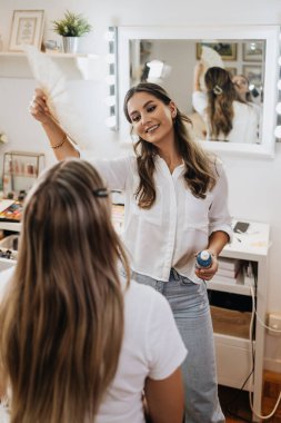 Makyaj süreci. Makyaj için makyaj yapan profesyonel bir sanatçı. Güzellik salonundaki güzel sarışın kadının portresini yakından çek..