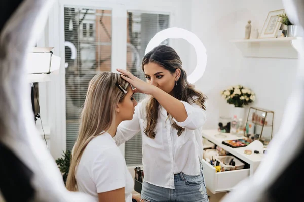 化妆的过程 专业的画家在模特脸上化妆 在美容院里的漂亮金发女人的近照 — 图库照片