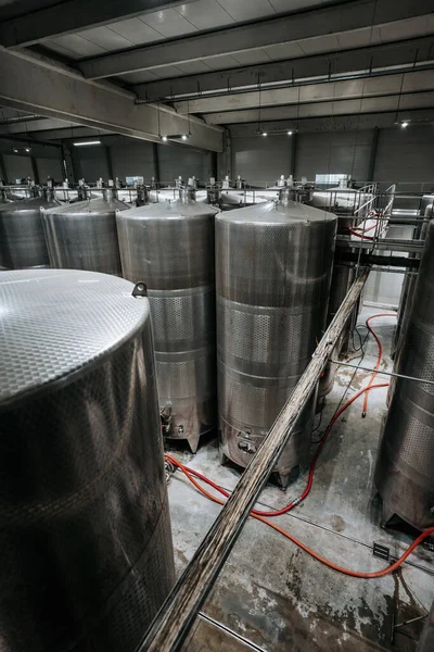 Huge warehouse for wine storing with giant stainless steel tanks. Industrial production of alcohol drink theme.