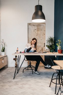 Kağıt tasarımcısı ve sanatçı atölyesinde ya da atölyesinde çalışıyor..