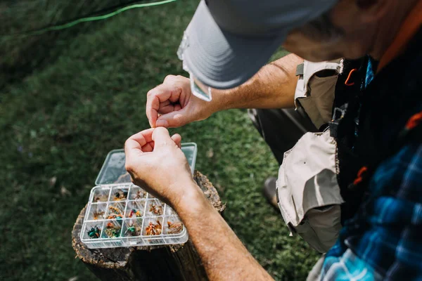 Balıkçılık için sinek bağlayan kıdemli balıkçıların yakın çekimleri. Balık tutma konsepti. 