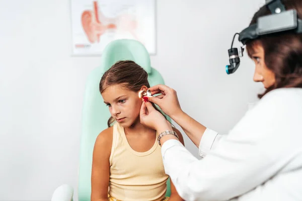Female Audiologist Examining Girl Ear Using Otoscope Doctors Office Child — ストック写真