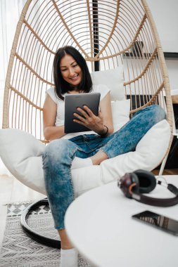 Güzel orta yaşlı kadın dairesinde yalnız oturuyor ve boş zamanlarında eğleniyor. Sohbet etmek ve müzik dinlemek için laptop ve tablet kullanıyor..