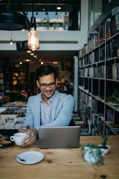 Giovane Bell Uomo Seduto Libreria Moderna Leggendo Usando Suo Computer — Foto Stock