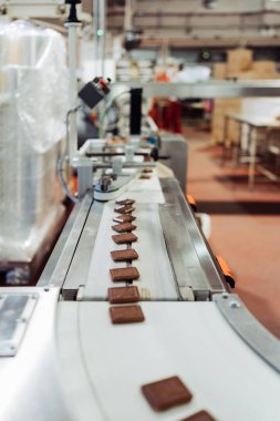 Tatlı yiyecek ve kurabiye üretimi için büyük bir fabrika hattı. Endüstriyel üretim sürecinin yakın çekim görüntüleri.