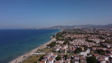 Yeşil manzaralı güzel mavi denizi ve villaları olan bir sahil kasabasının havadan görünüşü