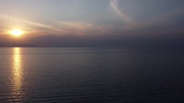 Sakin Sonsuz Deniz 'in üzerinde birkaç tekne siluetiyle Güzel Gün Batımının Hava Manzarası