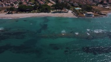 Teal Renkli Deniz ve Kahverengi Tarifli Güzel Kumsal Manzarası - Arkaplanda Villalar